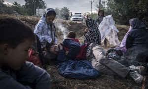 Refugees warm near the fire as they wait for escort being detained by Hungarian police after crossing the Serbia-Hungaria birder outside Asotthalom, Hungary, Sunday August, 23, 2015. (Photo Sergey Ponomarev for The New York Times) NYTCREDIT: Sergey Ponomarev for The New York Times